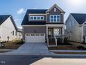 Inviting two-story home with gray exterior, white garage door, and brick stairs at 1713 Grassy Falls Ln, Wendell, NC 27591