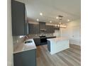 Modern kitchen with gray cabinets, island, and stainless steel appliances at 260 Chestnut Oak Ln, Lillington, NC 27546