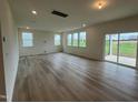 Spacious living room with hardwood floors and sliding glass doors to backyard at 260 Chestnut Oak Ln, Lillington, NC 27546