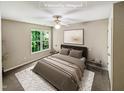Virtually staged bedroom with ceiling fan and large window at 4425 Woodlawn Dr, Raleigh, NC 27616