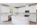 Modern kitchen with white cabinets, quartz island and stainless steel appliances at 81 Hank Way, Angier, NC 27501