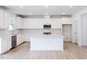 Modern kitchen with white cabinets, quartz island and stainless steel appliances at 81 Hank Way, Angier, NC 27501