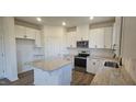 Modern kitchen with white cabinets, granite countertops, and stainless steel appliances at 466 Saint Clair Dr, Fuquay Varina, NC 27526