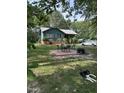 Green house with patio furniture and a fire pit in the yard at 7253 Hunt Valley Trl, Wendell, NC 27591