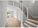Modern staircase with metal railing in a bright entryway at 4566 Ashtons Way, Franklinton, NC 27525