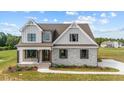 Two-story farmhouse-style home with stone accents and a landscaped yard at 4566 Ashtons Way, Franklinton, NC 27525