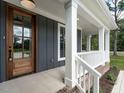 Inviting front porch with wooden door and white railings at 1000 Azalea Garden Circle, Raleigh, NC 27603