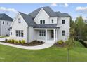 Two-story white brick home with a metal roof and landscaped yard at 2518 Silas Peak Ln, Apex, NC 27523