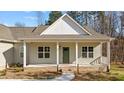 Close-up of a charming front porch with a green door, brick accents, and inviting entryway at 95 Leisure Ln, Louisburg, NC 27549