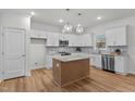 Modern kitchen featuring white cabinetry, an island with granite countertops, and stainless steel appliances at 95 Leisure Ln, Louisburg, NC 27549