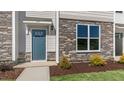 Exterior view of a townhome with blue door, stone accents, and landscaping at 863 Old Tarboro Rd, Wendell, NC 27591