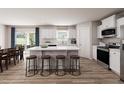 Open concept kitchen with island, white cabinets, and stainless steel appliances at 136 Coble Farms Pl, Fuquay Varina, NC 27526