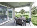 Covered patio with table and chairs, offering a view of the backyard at 136 Coble Farms Pl, Fuquay Varina, NC 27526