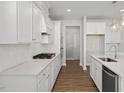 Modern kitchen with white cabinets and gas cooktop at 232 Gregory Village Dr, Lillington, NC 27546