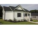 White farmhouse-style home with black shutters, front porch, and steps at 802 S Parrish St, Lillington, NC 27546