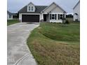Beige house with brown accents, double garage, and green lawn at 32 Scotties Ridge Dr, Princeton, NC 27569