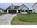 Beige house with brown accents, double garage, and green lawn at 32 Scotties Ridge Dr, Princeton, NC 27569