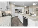 Open kitchen with white cabinets, granite countertops, and stainless steel appliances at 508 Impala Trce, Wendell, NC 27591