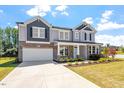 Two-story house with gray siding, stone accents, and a front porch at 541 Henham Way, Zebulon, NC 27597