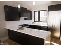 Modern kitchen with dark cabinetry, marble countertops, and stainless steel appliances at 512 Gordon St # 407, Durham, NC 27701