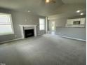 Open living room with high ceilings, fireplace, and kitchen view at 86 Scotties Ridge Dr, Princeton, NC 27569