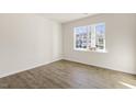 Bright bedroom with wood-look floors and large window at 405 Ashley Run, Sanford, NC 27330