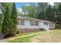 Beige single story home with light blue accents, white stairs, and a spacious yard at 1510 Logan St, Durham, NC 27704