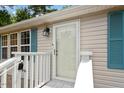 Front entry with a glass door, white railing, and teal shutters at 1510 Logan St, Durham, NC 27704