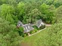 Aerial view of a house nestled in a lush green forest setting at 4099 Blackard Pond Rd, Raleigh, NC 27604