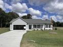Ranch-style home with attached garage and landscaped lawn at 184 Grace Ridge Ct, Benson, NC 27504