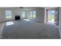 Spacious living room with fireplace, neutral carpet, and lots of natural light at 117 Grace Ridge Ct, Benson, NC 27504
