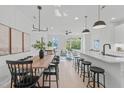 Open concept dining area with wood table and black chairs, adjacent to kitchen and living room at 600 Rocky Knob Ct, Raleigh, NC 27601