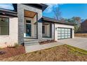 Modern two-story home with brick and stone exterior, attached garage, and covered porch at Lot 4 Harding St, Efland, NC 27243