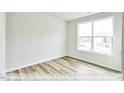 Bright bedroom with wood-look flooring and a large window at 1677 Abberly Pl, Graham, NC 27253