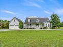 White farmhouse with large yard and detached garage at 557 Olives Chapel Rd, Apex, NC 27502