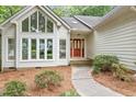 Front entrance with a wood door and pathway, surrounded by landscaping at 8116 Windsor Ridge Dr, Raleigh, NC 27615