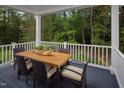 Deck with wooden table and chairs, overlooking wooded area at 8813 Tartan Clan Dr, Willow Springs, NC 27592