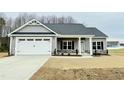 Gray house with white garage door, stone accents, and a covered porch at 144 Emerson Fields Dr, Pikeville, NC 27863