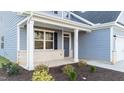 Front porch with gray siding, white columns, and landscaping at 110 Merrifield Ln, Garner, NC 27529
