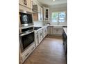 Modern kitchen with white cabinets, stainless steel appliances, and farmhouse sink at 317 Kavanaugh Rd, Wake Forest, NC 27587