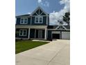 Two-story house with a gray exterior, two-car garage, and landscaped lawn at 317 Kavanaugh Rd, Wake Forest, NC 27587