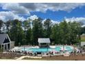 Resort-style community pool with ample lounge chairs and cabana at 116 Augusta Pond Way # 140, Raleigh, NC 27603