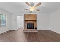 Living room featuring a brick fireplace and wood-look floors at 4413 Old Colony Rd, Raleigh, NC 27613