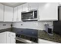 Modern kitchen with granite countertops and stainless steel appliances at 222 Glenwood Ave # 307, Raleigh, NC 27603