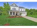 Two-story white house with gray roof, stone accents, and a two-car garage at 81 Eagle Crest Ct # Apex Craftsman, Lillington, NC 27546