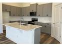 Modern kitchen with gray cabinets, quartz countertops and island at 150 Chestnut Oak Ln, Lillington, NC 27546