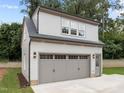 Detached three-car garage with dormer windows and light-grey siding at 2646 Marchmont St, Raleigh, NC 27608