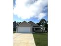 Newly built beige house with a white garage door and landscaping at 32 Oakfield Trace Dr, Four Oaks, NC 27524