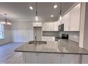 Modern kitchen with white cabinets, granite countertops, and stainless steel appliances at 153 Wilderness Trl, Smithfield, NC 27577