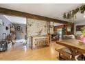 Open concept living and dining area with exposed beams and brick feature wall at 2419 Mount Gilead, Pittsboro, NC 27312